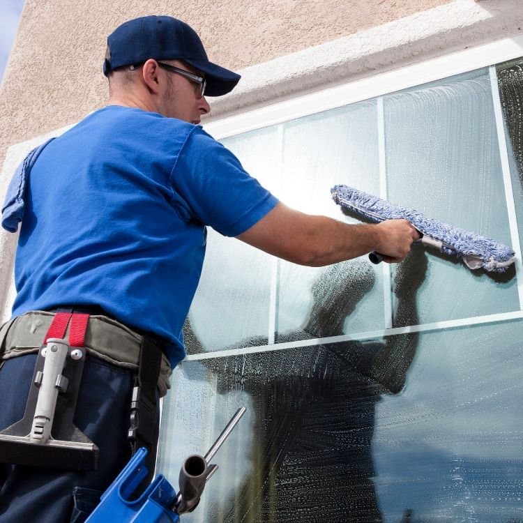 Arizona Window Washers professional cleaning a home window with a squeegee